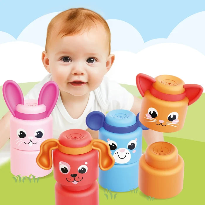 A smiling baby behind colorful, animal-faced stacking blocks including a pink bunny, red dog, and blue bear.