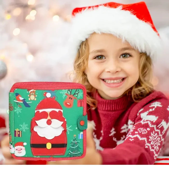A girl in a Santa hat holds a green and red felt activity book with a Santa Claus and reindeer design.