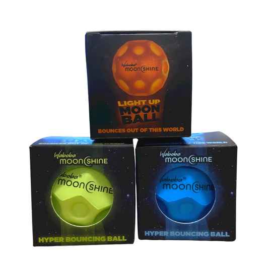 Three black boxes showing orange, green, and blue light-up bouncing balls with a cratered moon-like texture.
