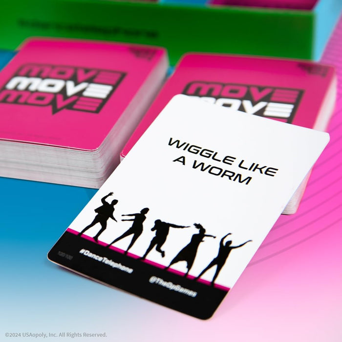 White game card reading WIGGLE LIKE A WORM with dancing silhouettes, in front of vibrant pink card stacks.