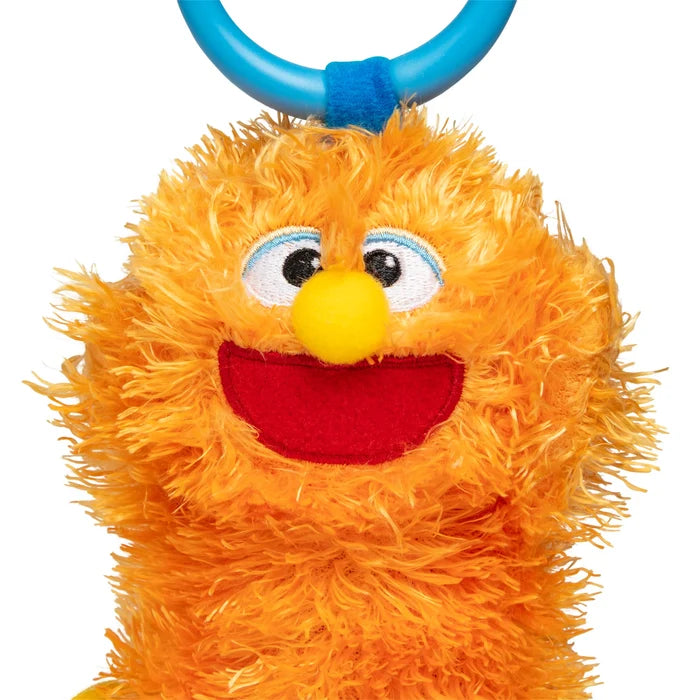 Fuzzy orange monster plush with a yellow nose, wide red mouth, and a blue plastic take-along ring.