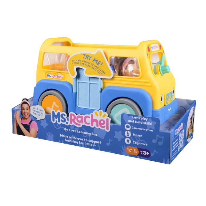 Yellow toy bus with blue fenders and wheels in blue packaging featuring Ms. Rachel and a "Try Me" arrow sticker.