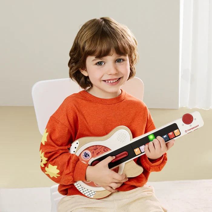 Smiling child holds a wooden toy guitar featuring white trim, colorful lettered buttons, and a black neck.