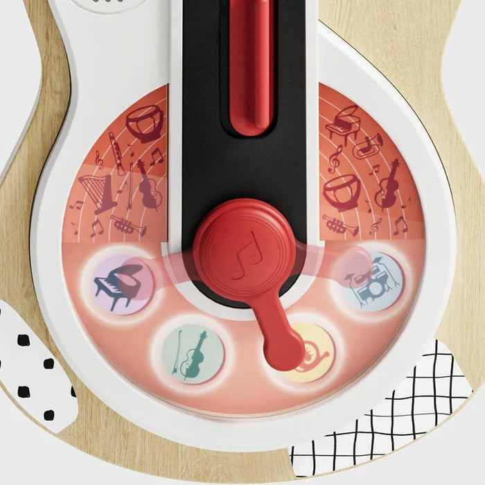 Close-up of a wooden toy guitar with a red rotating dial and icons for piano, violin, horn, and drums.