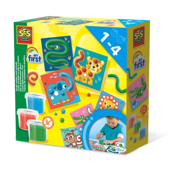 Yellow toy box featuring colorful animal cards, three tubs of dough, and a toddler playing.