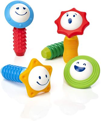 Four colorful magnetic sensory toys with textured handles, shaped rattle heads, and white expressive faces.