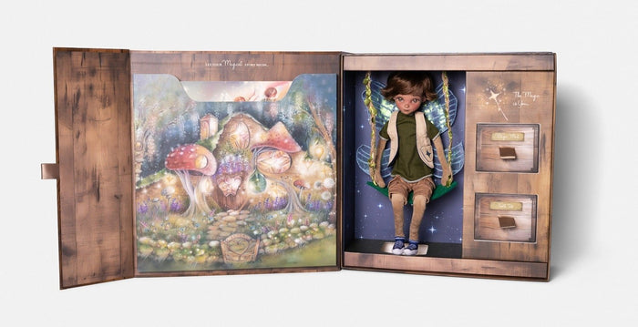 Open wooden box featuring a boy fairy doll on a swing, colorful forest artwork, and two small storage drawers.