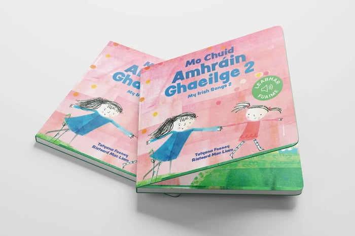 Two children's books titled Mo Chuid Amhráin Ghaeilge 2 featuring pink covers and hand-drawn illustrations of girls.