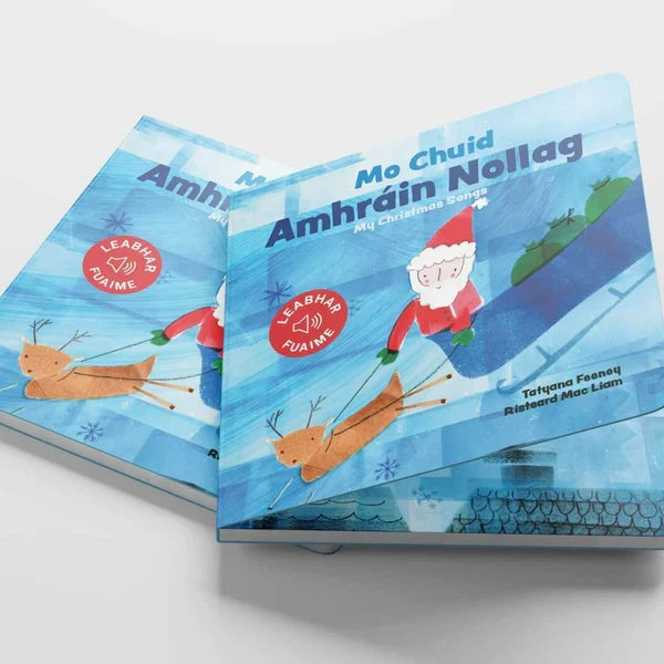 Two blue Mo Chuid Amhráin Nollag sound books featuring a cartoon Santa in a sleigh pulled by a reindeer.