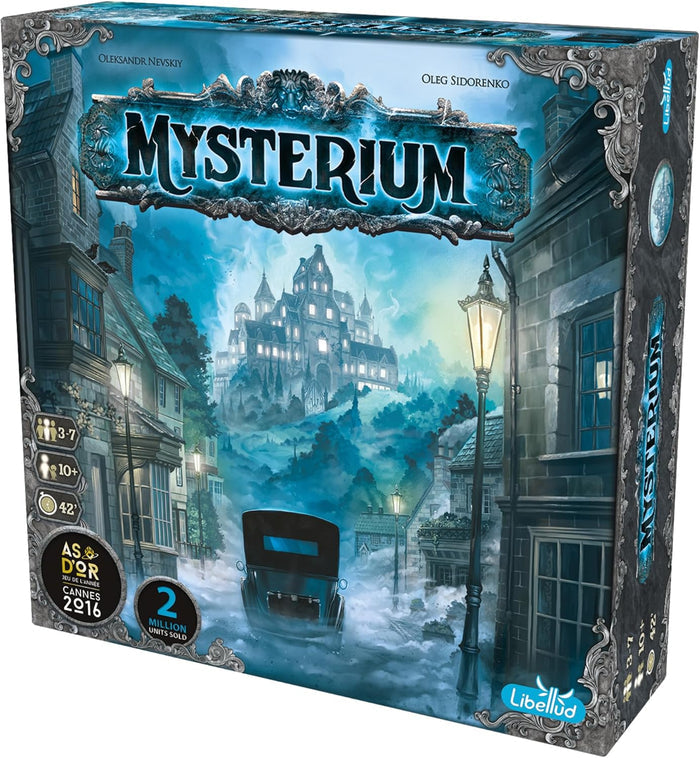 Blue board game box with ornate silver borders, showing a misty night scene with a haunted mansion and a vintage car.