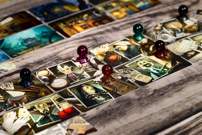 Close-up of illustrated board game cards and translucent colored tokens arranged on a wooden surface.
