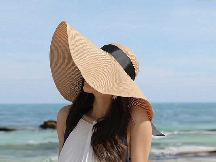 Navy women's straw sun hat with 16cm wide brim, floppy derby style, perfect for summer beach and outdoor sun protection.
