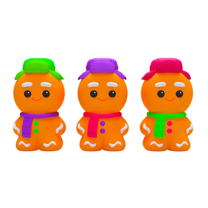 Three orange gingerbread man figures with neon green, purple, and pink winter hats and scarves and smiling faces.