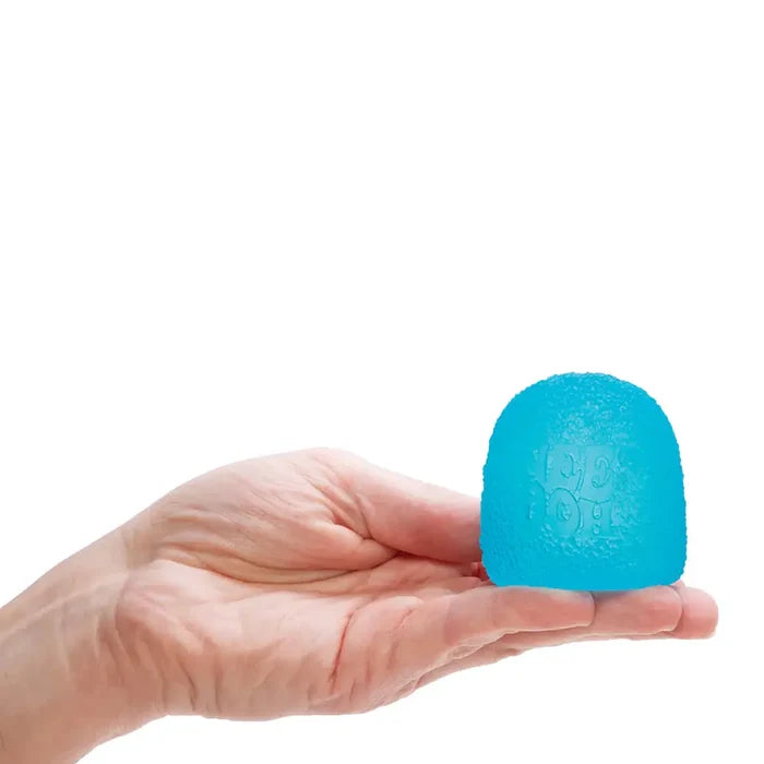 A small, teal, gumdrop-shaped toy with a bumpy surface and embossed logo, held in an open hand.