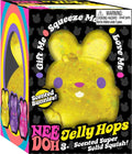 Yellow bunny-shaped squeeze toy with purple eyes and colorful specks in a black decorative display box.