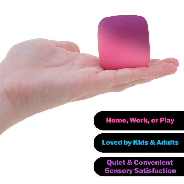 A small, rounded pink and purple gradient squishy toy cube held in an open hand.