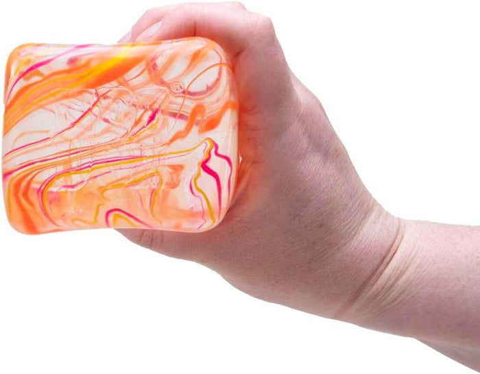 Hand squeezing a rectangular translucent squishy toy with vibrant orange and pink marbleized swirls.