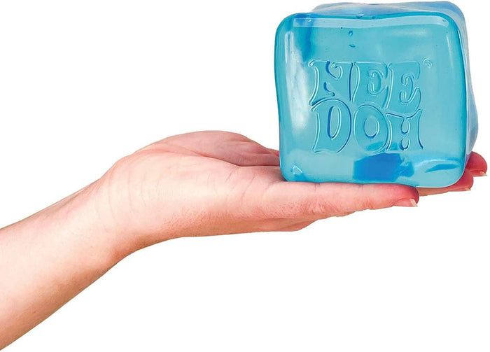 Translucent blue cube-shaped squishy toy with NEE DOH embossed on the front, resting on an open palm.