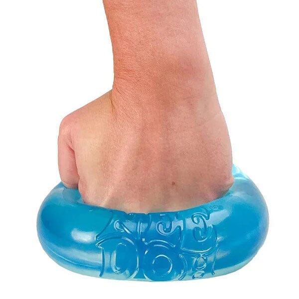 Hand pressing into a translucent blue, ring-shaped squishy toy with embossed lettering on the surface.