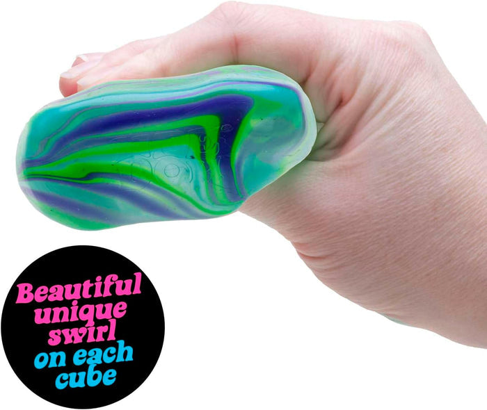 A hand squeezes a translucent squishy cube with vibrant swirls of blue, purple, and green.