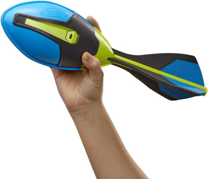 Hand holding a blue and neon green foam rugby ball with a textured black grip and a long, three-finned tail.