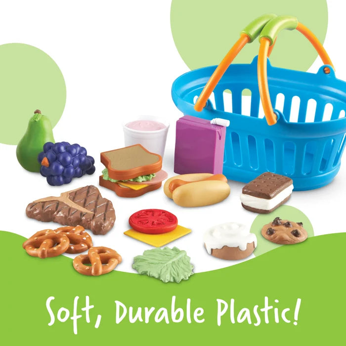Colorful plastic play food set with a blue shopping basket, sandwich, and fruit. Text: Soft, Durable Plastic!