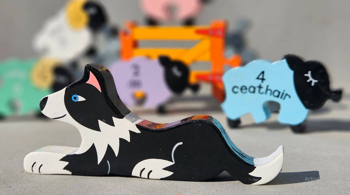 Hand-painted wooden border collie toy in front of a blue sheep puzzle piece labeled with number 4 and Irish word ceathair.