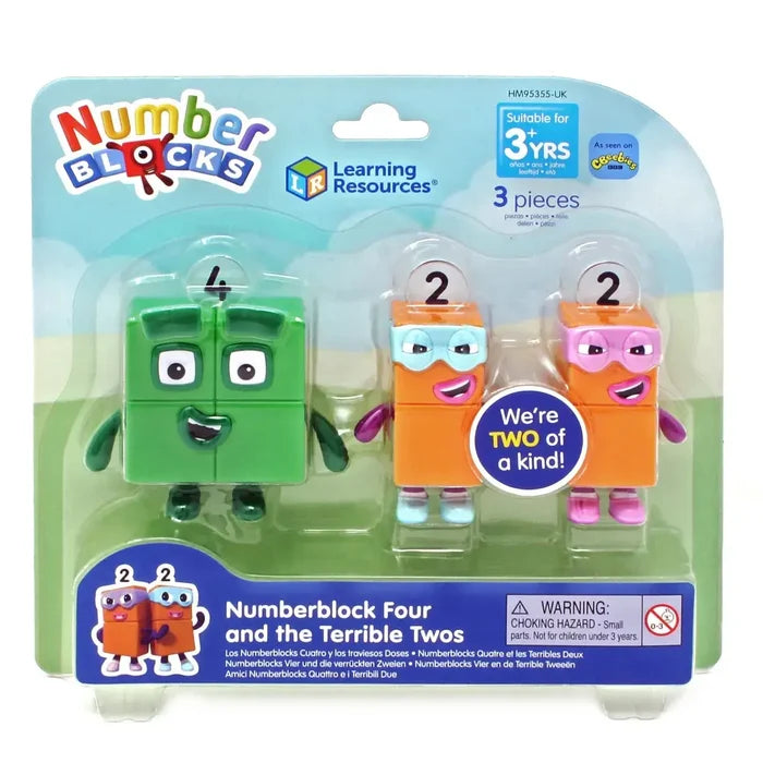 Green square toy and two orange masked rectangular figures inside a clear plastic retail blister pack.