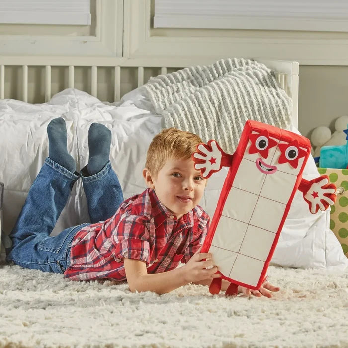 Large red and white rectangular plush toy with ten grid squares and star-shaped eyes, held by a child.
