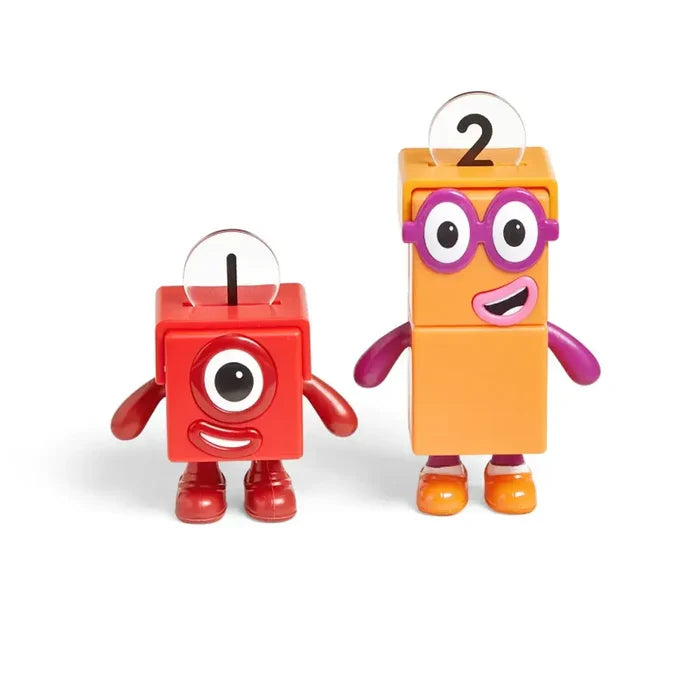 Red square figurine and taller orange figurine with purple glasses, both wearing clear plastic helmets.