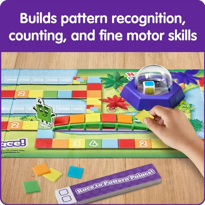 Child places colorful tiles on a path near a character piece, dice popper, and game cards.