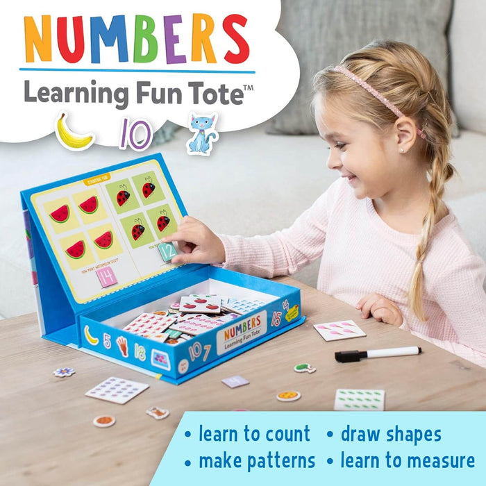 A girl uses a blue fold-out activity tote with magnetic numbers and colorful illustrated cards on a wooden table.