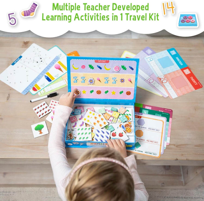 Child playing with a blue learning tote filled with colorful number and pattern activity cards on a wooden table.