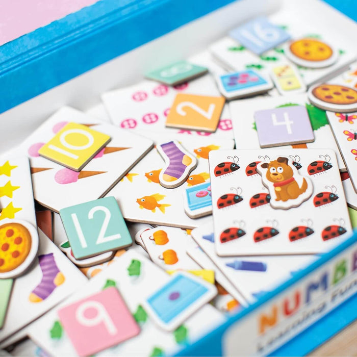 Blue box overflowing with colorful square number and picture tiles featuring ladybugs, pizza, and socks.