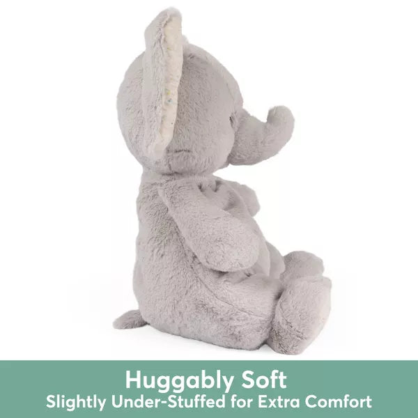 Side view of a grey plush elephant. Text: Huggably Soft, Slightly Under-Stuffed for Extra Comfort.