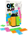 OK Play game packaging with stacks of orange and green square tiles on a black clip and loose colorful tiles in front.