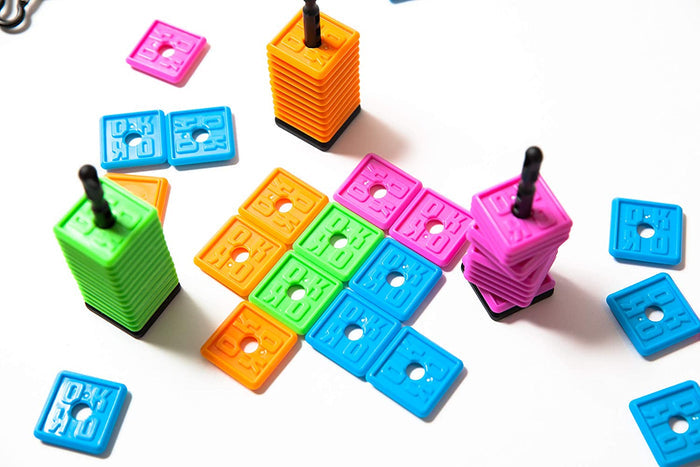 Colorful pink, blue, orange, and green square tiles embossed with OK, some stacked on black spindles.