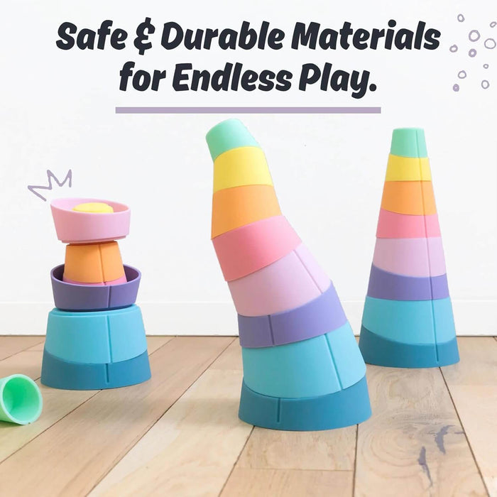 Pastel-colored silicone stacking cups arranged in straight, curved, and nested towers on a light wood floor.