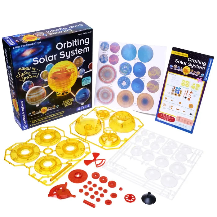 Orbiting Solar System kit box with yellow gear frames, red plastic parts, clear domes, and colorful planet stickers.