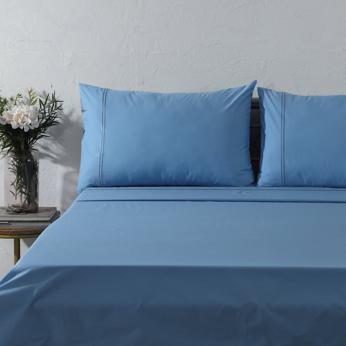 Organic cotton coloured sheet set in blue mirage with 250-thread count from Whites of London NZ, featuring neatly folded bedsheets.