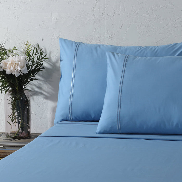 Organic cotton coloured sheet set in blue mirage with 250 thread count, featuring neatly made sheets and pillowcases.