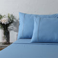 Organic cotton coloured sheet set in blue mirage with 250 thread count, featuring neatly made sheets and pillowcases.