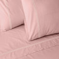 Dusty pink organic cotton sheet set by Whites of London NZ, 250 thread count, showing the soft, pastel-colored bed sheets.