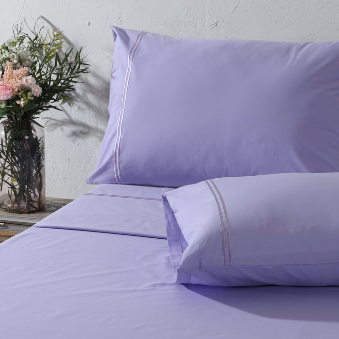 Organic cotton lavender mist sheet set with colorful, soft 250 thread count fabric, featuring neatly made lavender-colored sheets.