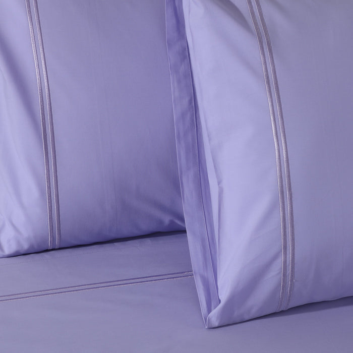 Organic cotton lavender mist sheet set with colorful design and 250 thread count, featuring a neatly made bed with the sheets visible.