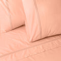 Organic cotton coloured sheet set in peach nectar with embroidery, 250 thread count from Whites of London NZ.