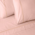 Organic cotton coloured sheet set in peach parfait with 250 thread count from Whites of London NZ, showing neatly made bed with soft sheets.