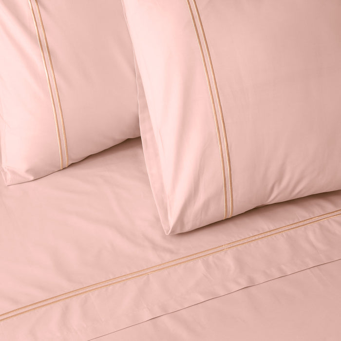 Organic cotton coloured sheet set in peach parfait with 250 thread count from Whites of London NZ, showing neatly made bed with soft sheets.