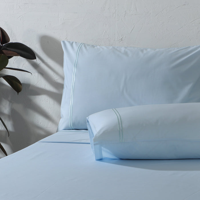Organic cotton coloured sheet set in sky blue with 250 thread count from Whites of London NZ, featuring neatly folded sheets.
