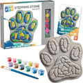 Paw-shaped mosaic stone kit with grey unpainted stone, 12 paint pots, brush, and guide showing a finished design.